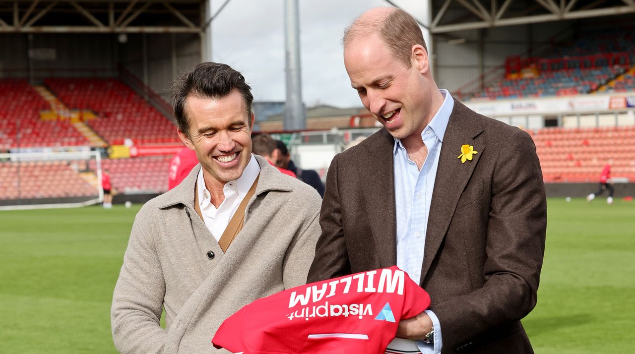 Chairman of Wrexham AFC Rob McElhenney and Prince William, Prince of Wales with his personalised Wrexham AFC shirt on the pitch at the Racecourse Ground after his visit to The Turf Pub, near Wrexham AFC as he marks St. David&#039;s Day on March 01, 2024 in Wrexham, Wales.