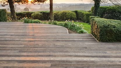 curved decked terrace fitted with Millboard Enhanced Grain Antique Oak