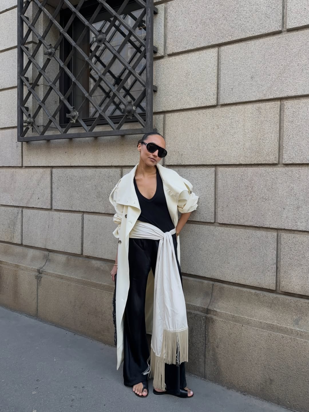 Woman in a black outfit with a silk scarf belt