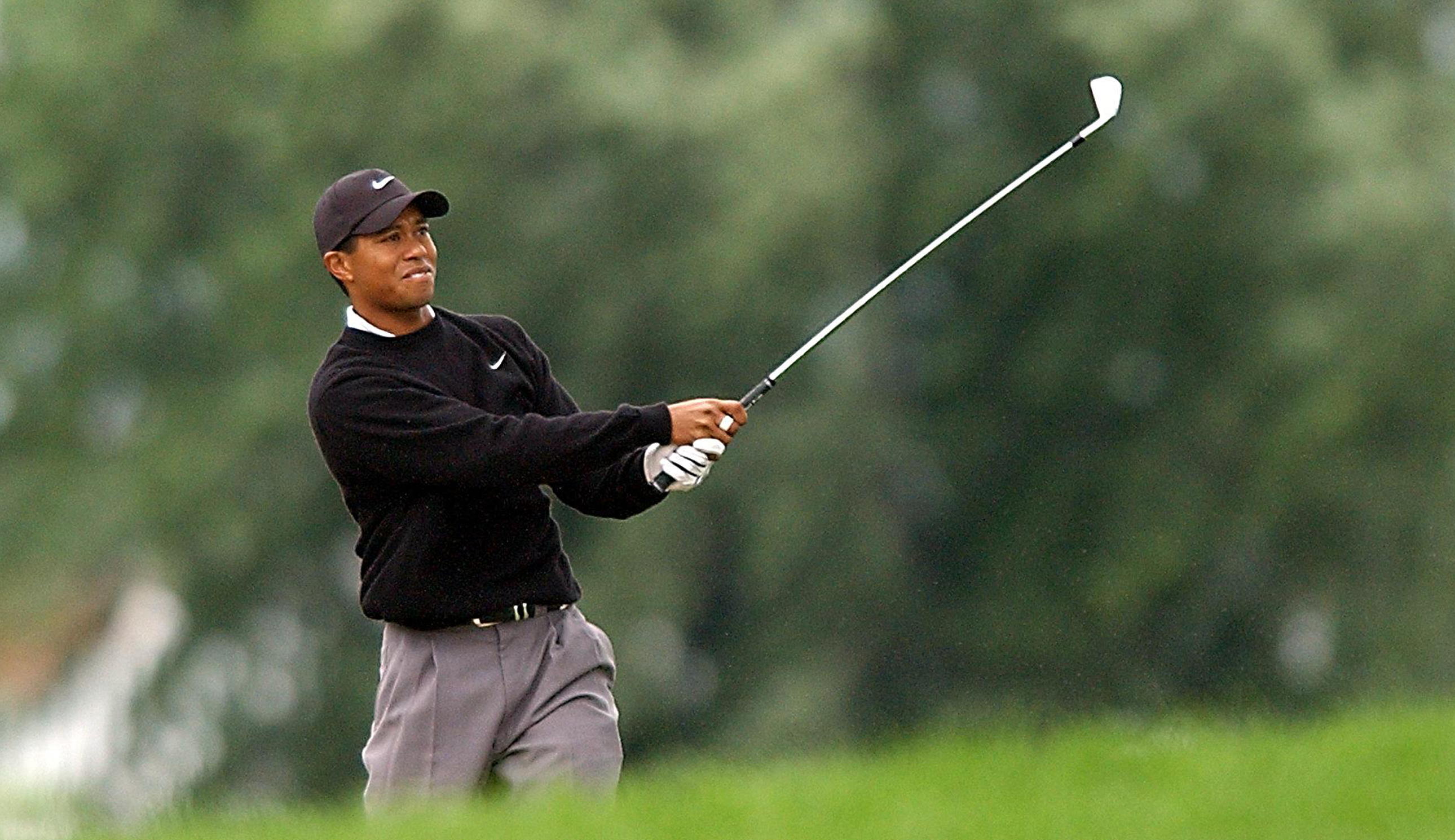 Tiger Woods hits an iron shot out of the bunker