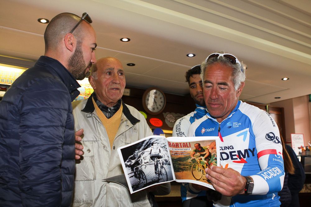 Ran Margaliot, Ivo Faltoni, Aviv Yechezkel and Sylvan Adams look over a book on Bartali