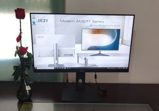 MSI Modern AM271P 11M con el fondo de escritorio de la marca.
