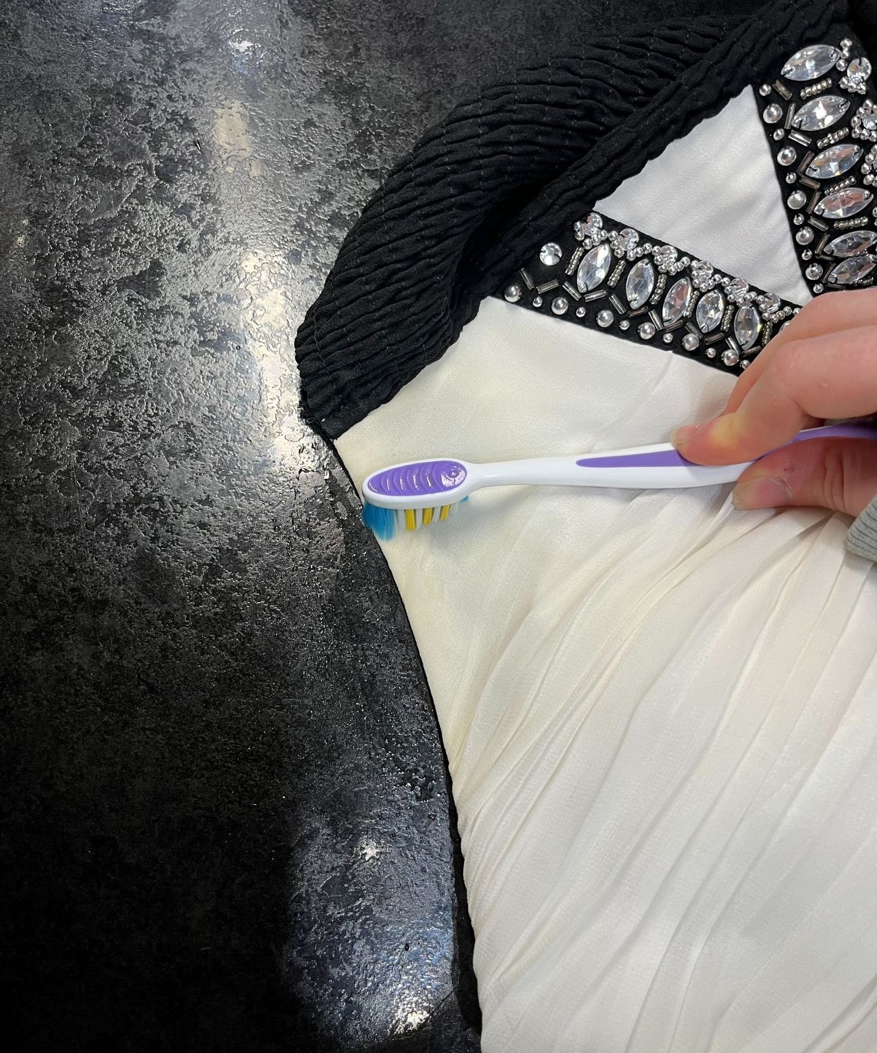 Scrubbing at a yellow stain with a purple toothbrush