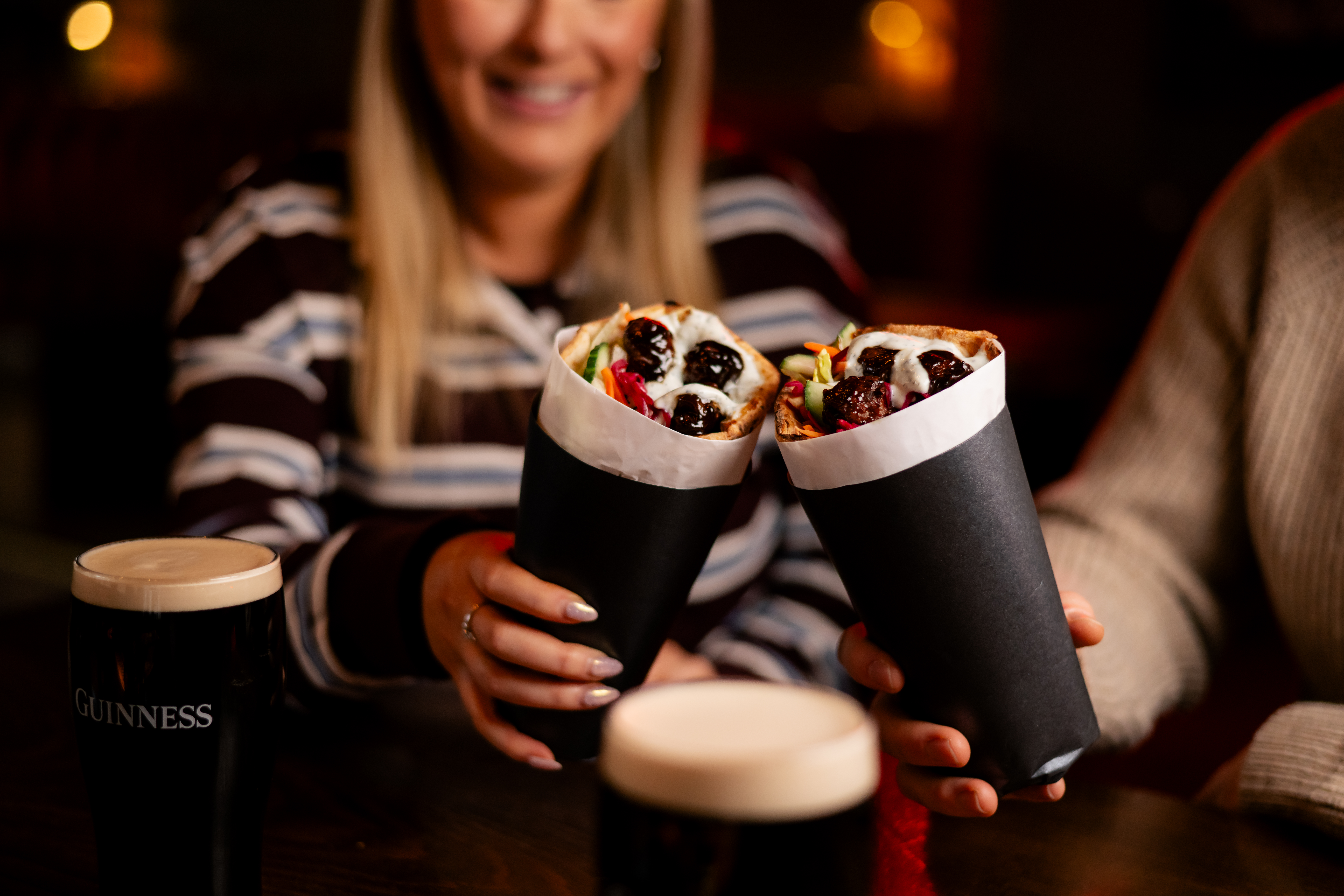 an image of two people cheersing with the kebabs