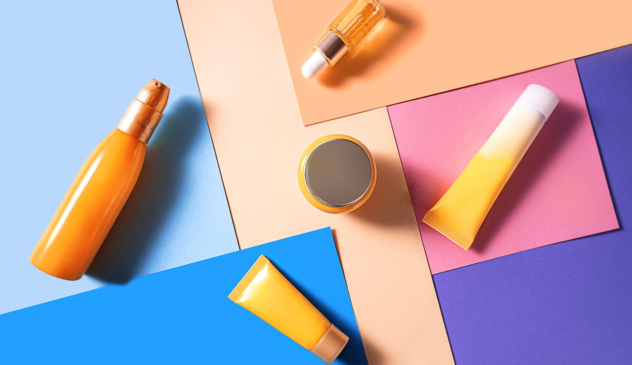 collection of orange sunscreen containers on a geometric background