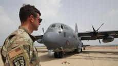 A U.S. soldiers stands in front of an AC-130 gunship in South Korea
