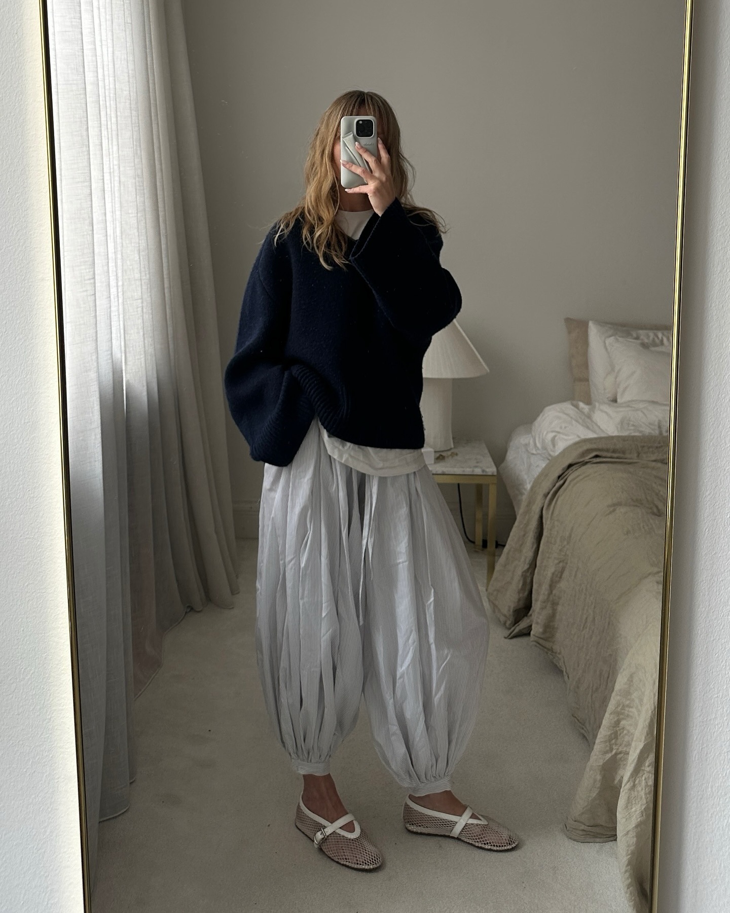 @_jeanettemadsen_ wearing a navy blue sweater with white striped genie pants.