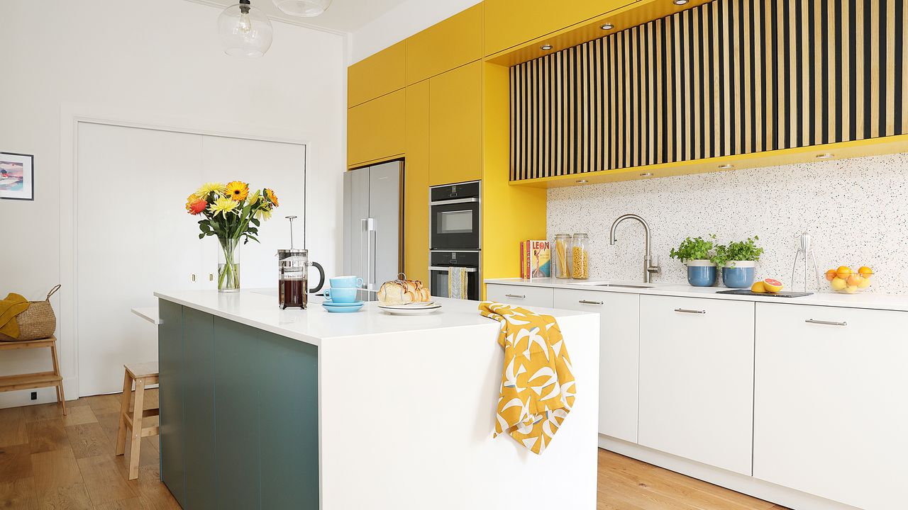 White and bold yellow kitchen with large kitchen island and terrazzo splashbacks