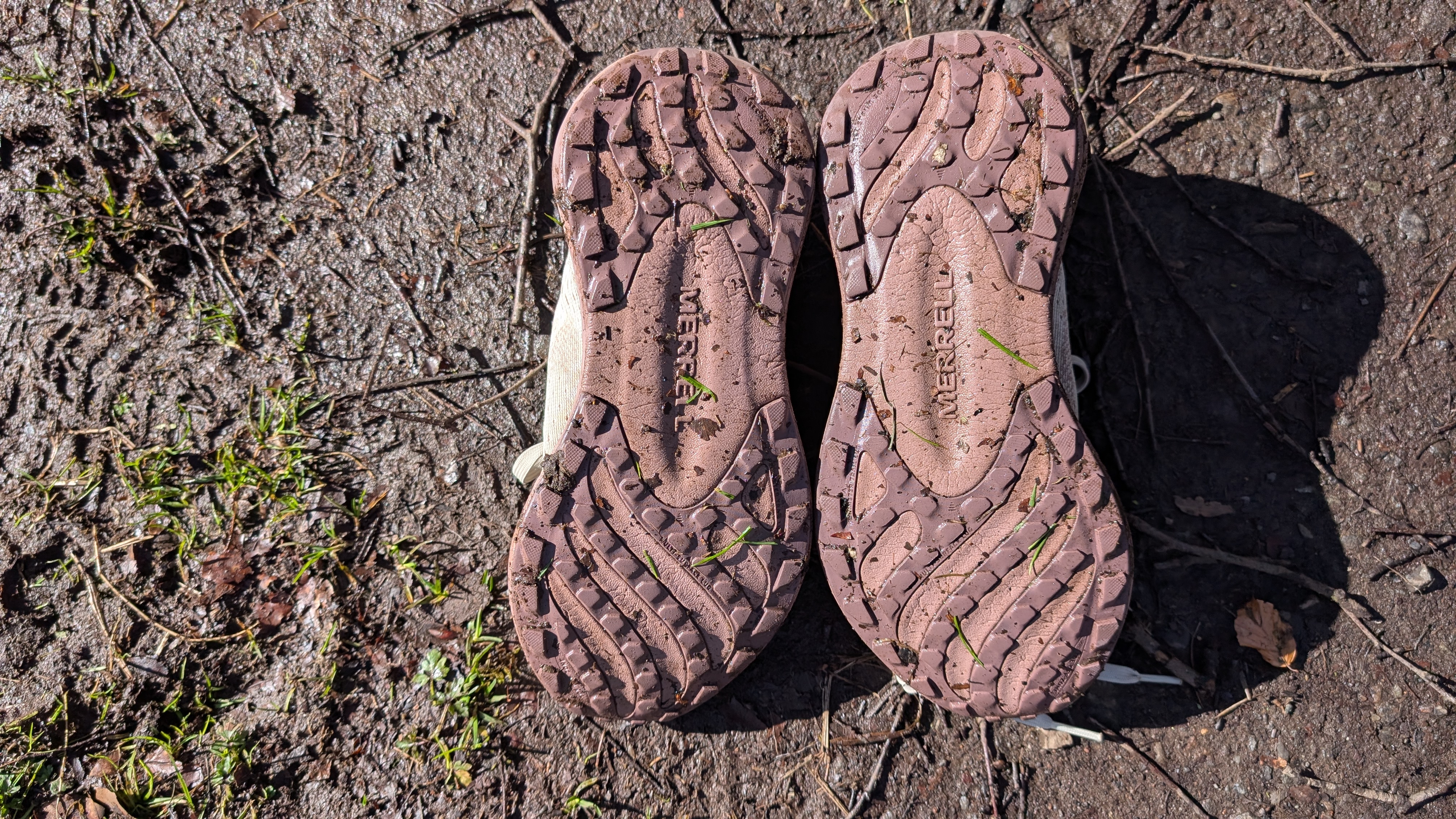 The soles of the Merrell Morphlite trail running shoes lying on the trail