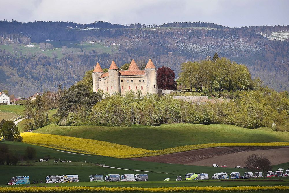 Castle Chateau Kastee overlooks a line of team buses at the Tour de Romandie