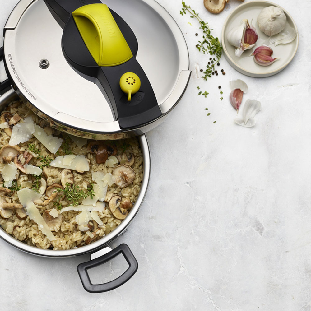 pressure cooker with food and white bowl with garlic