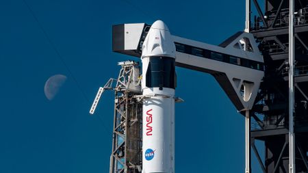 a white and black rocket with NASA markings on it stands poised on a launch pad awaiting its day to launch