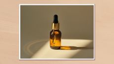 Image of a bottle of serum in the rays of the sun in a white frame on a beige background