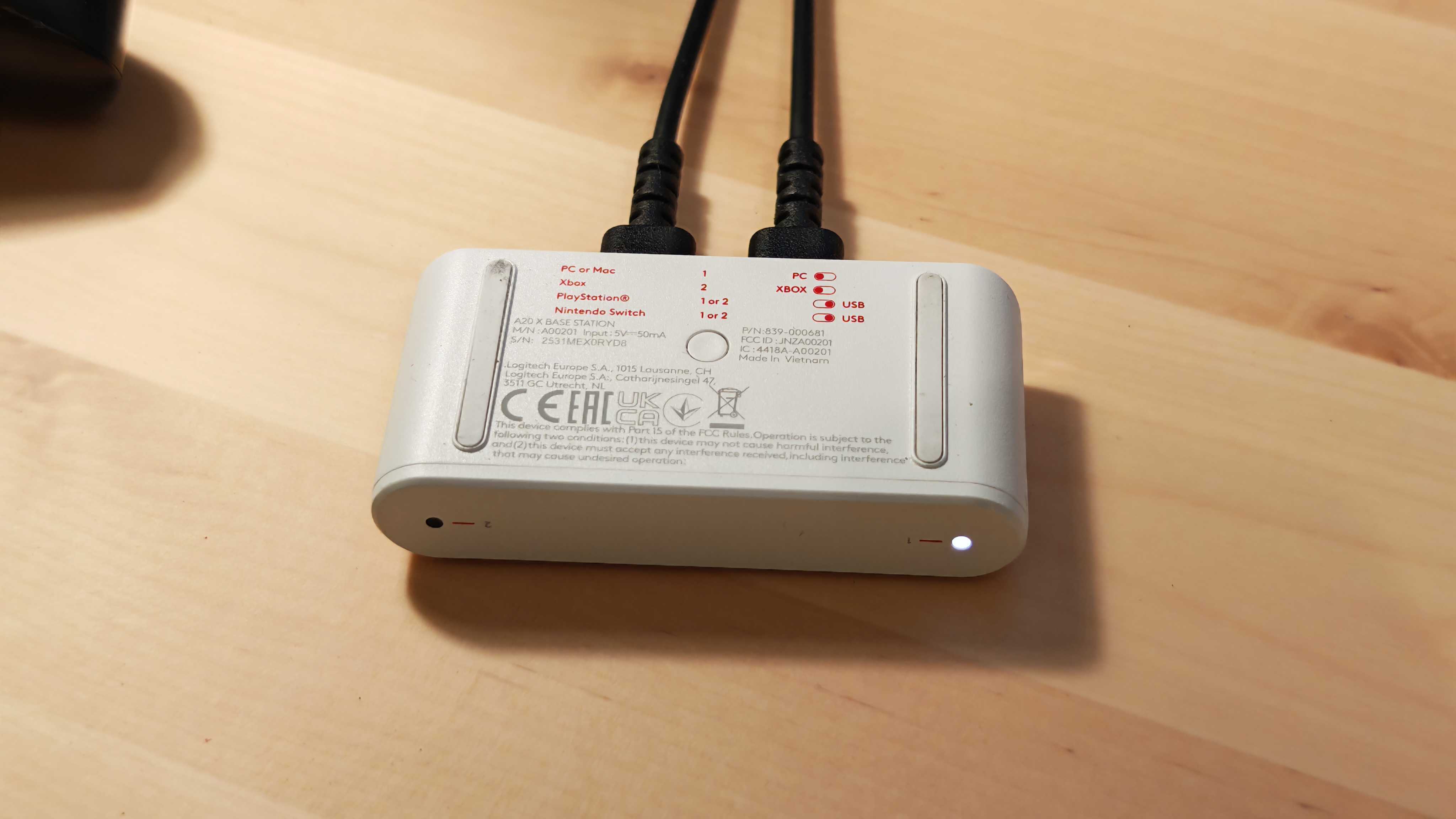 The Astro A20 X gaming headset on a wooden desktop surface.