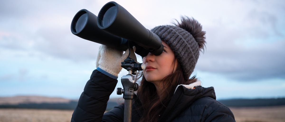 woman using binoculars to look at the sky