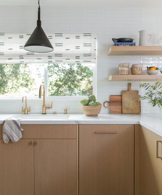 small kitchen with wooden cabinets and floating shelves