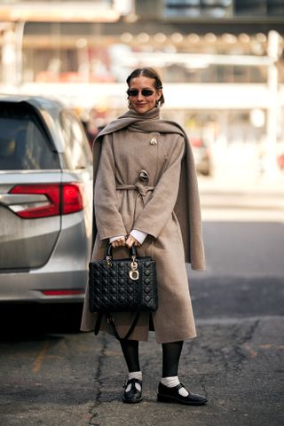 woman wearing trench coat, leggings, mary janes, and socks