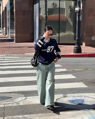 Woman crossing the street in a jersey.