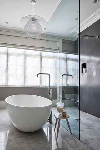 modern bathroom with open plan design, polished floor tiles, white tub, walk in shower, glass shower wall, white pendant