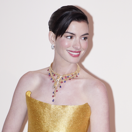 Actress Anne Hathaway attends the opening ceremony of Bvlgari Infinity Serpents Exhibition on January 8, 2025 in Shanghai, China in a gold midi dress