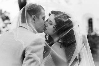 Bride and groom kiss under the veil.