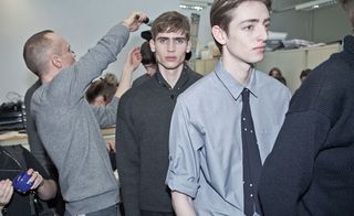 A line of models dressed smart casual, with one looking directly at the camera