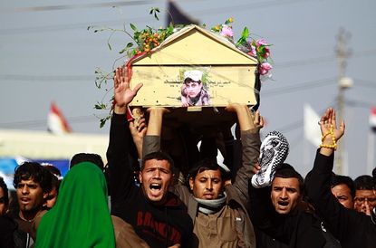 Iraqi mourners carry the body of a soldier who died in a U.S.-led airstrike