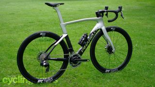 A black and silver Pinarello Dogma F stands at an angle on a grass surface