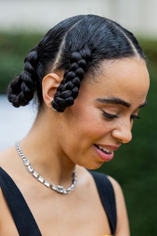 Mujer de cabello negro con trenzas de aro retorcidas GettyImages-2018780028