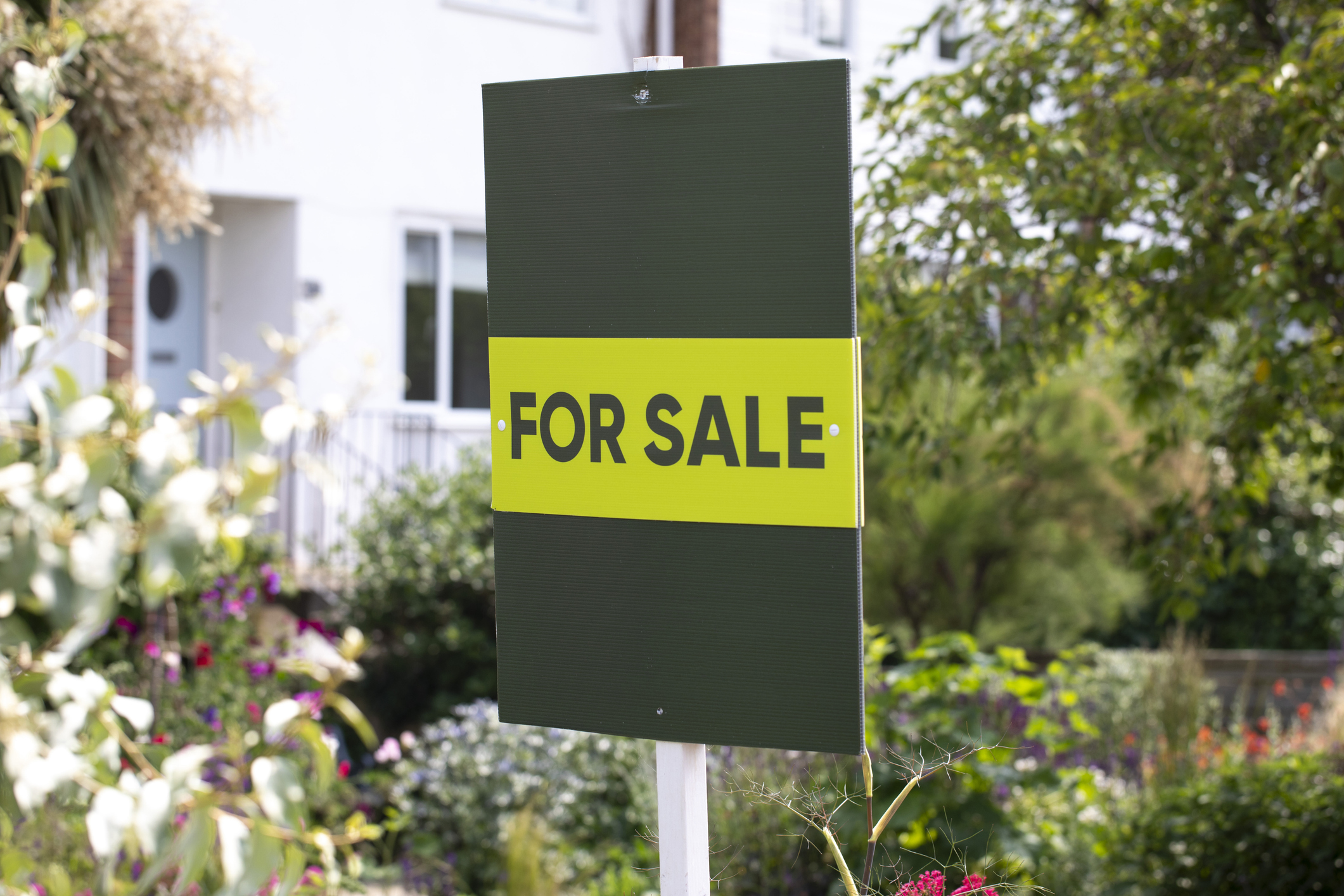 For sale sign outside a house in summer