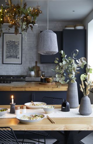 a black and white strung light from Dunelm over a winter festuve table in a kitchen with wood worktops