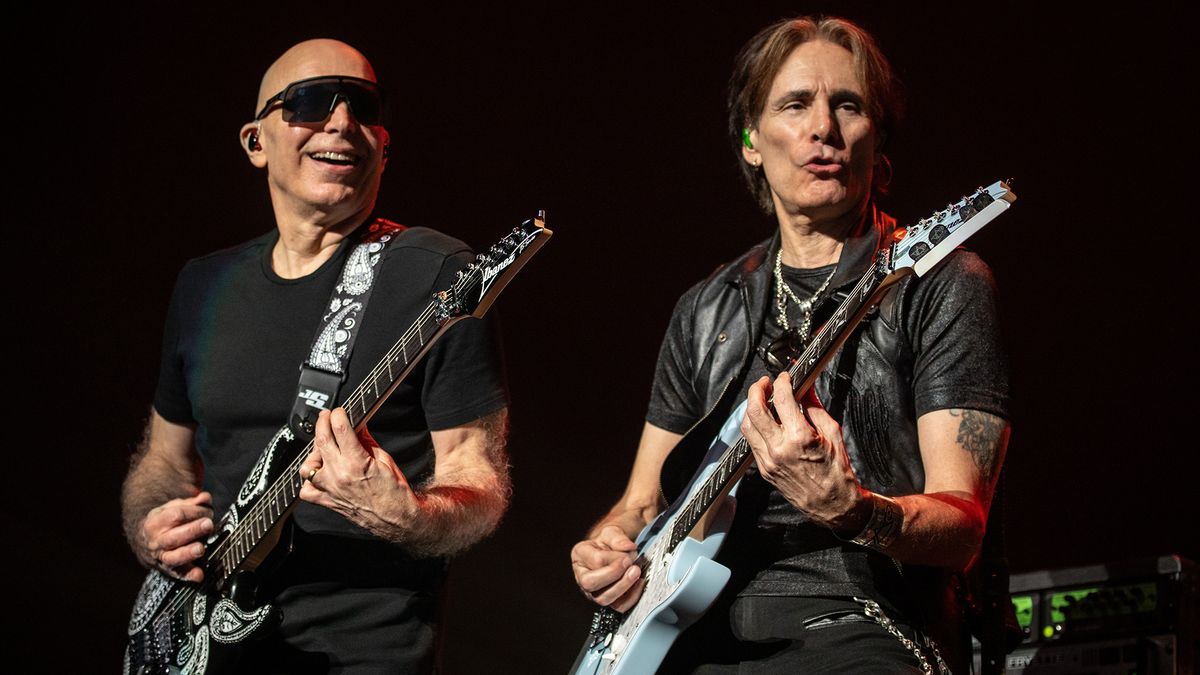 Joe Satriani and Steve Vai playing guitar together on stage