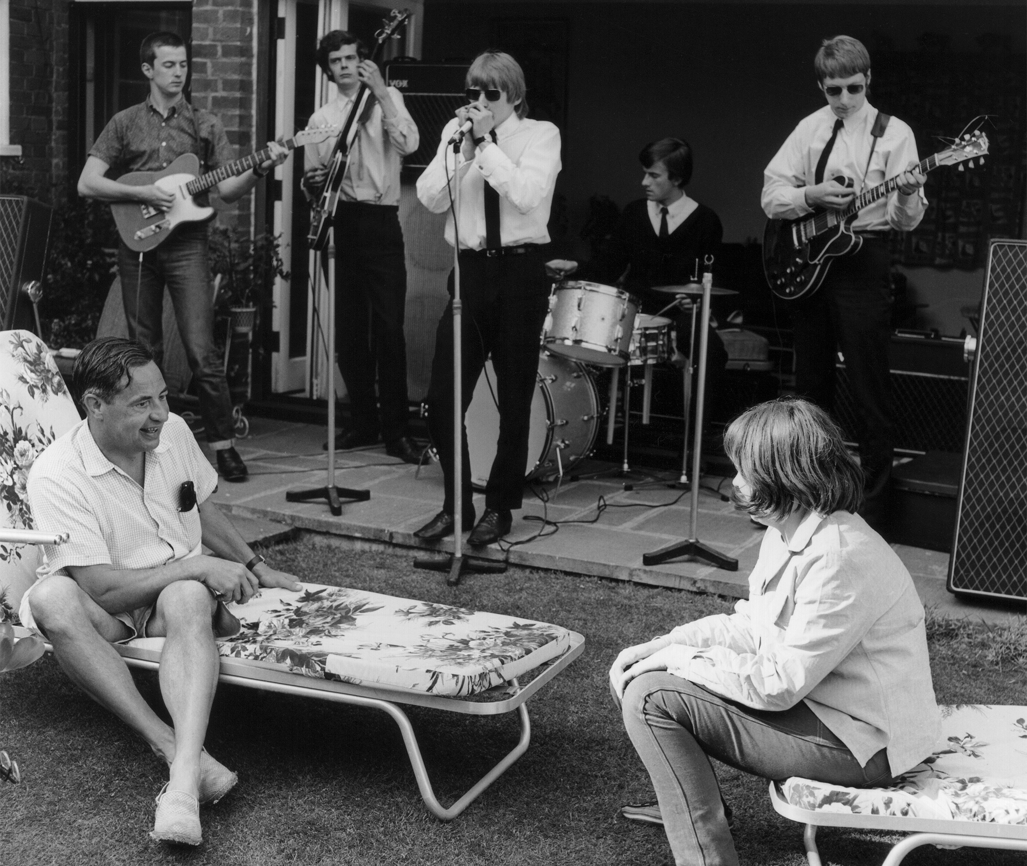British blues band The Yardbirds perform for screenwriter Lord Ted Willis in his garden in Chislehurst, Kent, 1964. L to R Lord Ted Willis (sitting, front), Eric Clapton, Paul Samwell-Smith, Keith Relf, Jim McCarty, Sally Willis (sitting, front), Chris Dreja.