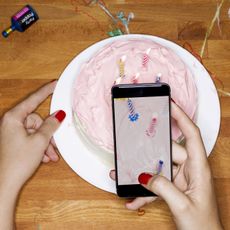 Taking picture with phone of cake with candles