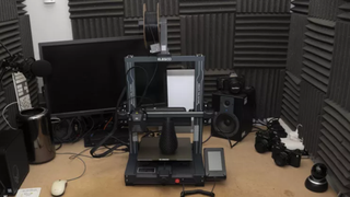 Elegoo Neptune 4 Pro 3D printer on a desk in a padded sound booth