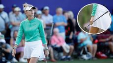 Nelly Korda walks on holding a putter