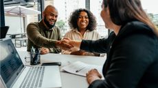 Insurance shoppers shake hands with an insurance professional at her office. 