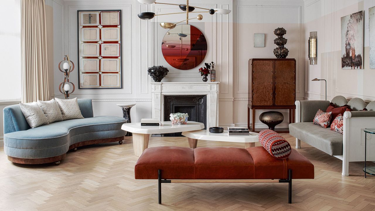 traditional eclectic living room with daybed, blue sofa, fireplace, pendant light and parquet floors