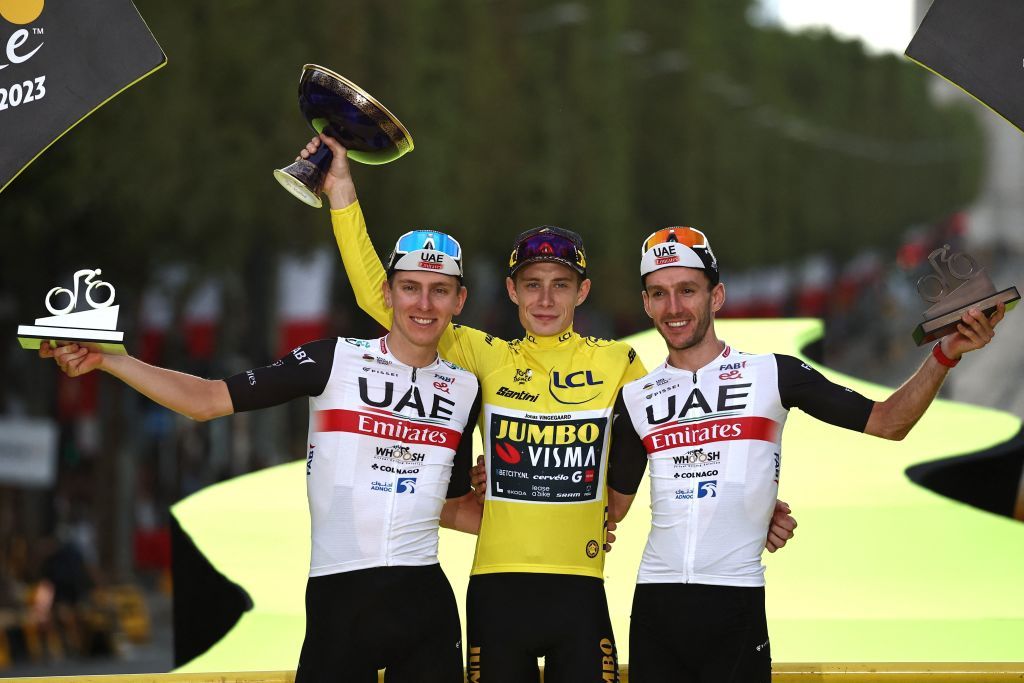 TOPSHOT JumboVismas Danish rider Jonas Vingegaard wearing the overall leaders yellow jersey C UAE Team Emirates Slovenian rider Tadej Pogacar in overall second place L and UAE Team Emirates British rider Adam Yates in overall third place R celebrate on the podium after the 21st and final stage of the 110th edition of the Tour de France cycling race 115 km between SaintQuentinenYvelines and the ChampsElysees in Paris on July 23 2023 Photo by AnneChristine POUJOULAT AFP Photo by ANNECHRISTINE POUJOULATAFP via Getty Images