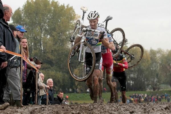 Niels Albert leads the front trio in the run through the mud