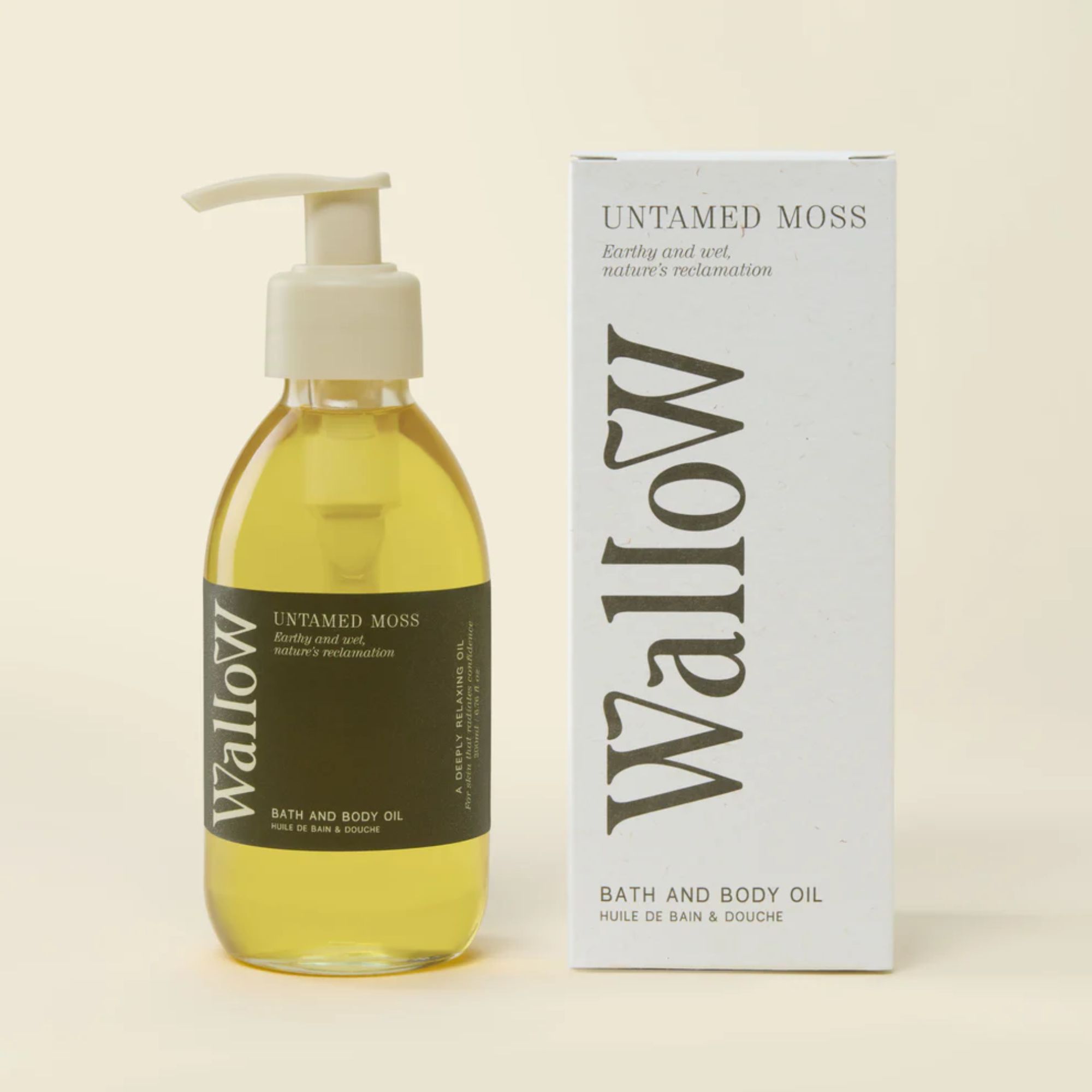 Clear bottle of bath and body oil with green label and white box