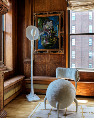 image of a corner of a living room with wooden walls and a round, fuzzy accent chair