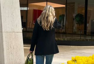 Eliza Huber wearing a black Liberowe blazer and blue Levi's 501 jeans with a green Prada bag.