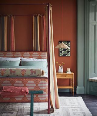 Warm colourful cozy bedroom ideas with four poster bed and terracotta painted walls.