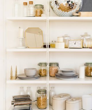 Tidy white kitchen pantry with glass storage jars