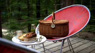 A woven basket delivering breakfast is laid out on the terrace at Loire Valley Lodges