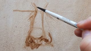 A pen drawing a nose on canvas