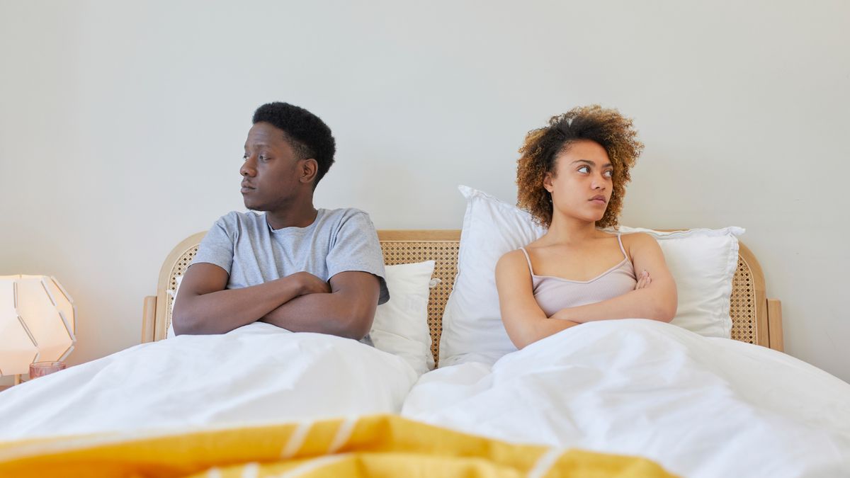 A couple angry at each other while lying in bed