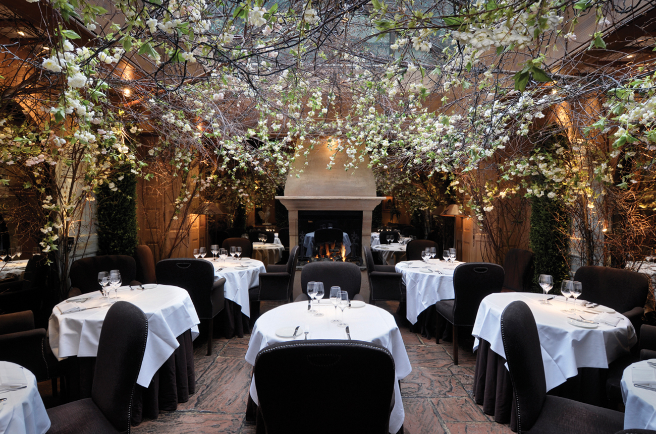 Restaurant tables in a conservatory filled with blossoms