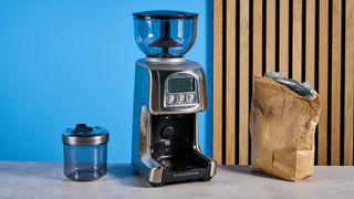 the casabrews tornado coffee grinder in silver showing the LED screen, grind adjustment dial, and photographed against a blue background 